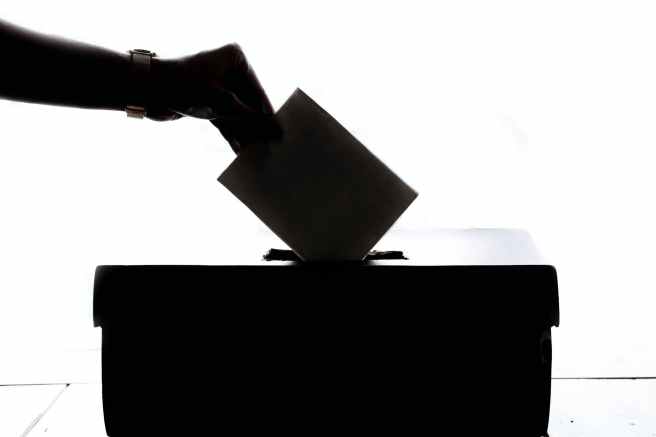 Vignette of someone putting a ballot into a ballot box